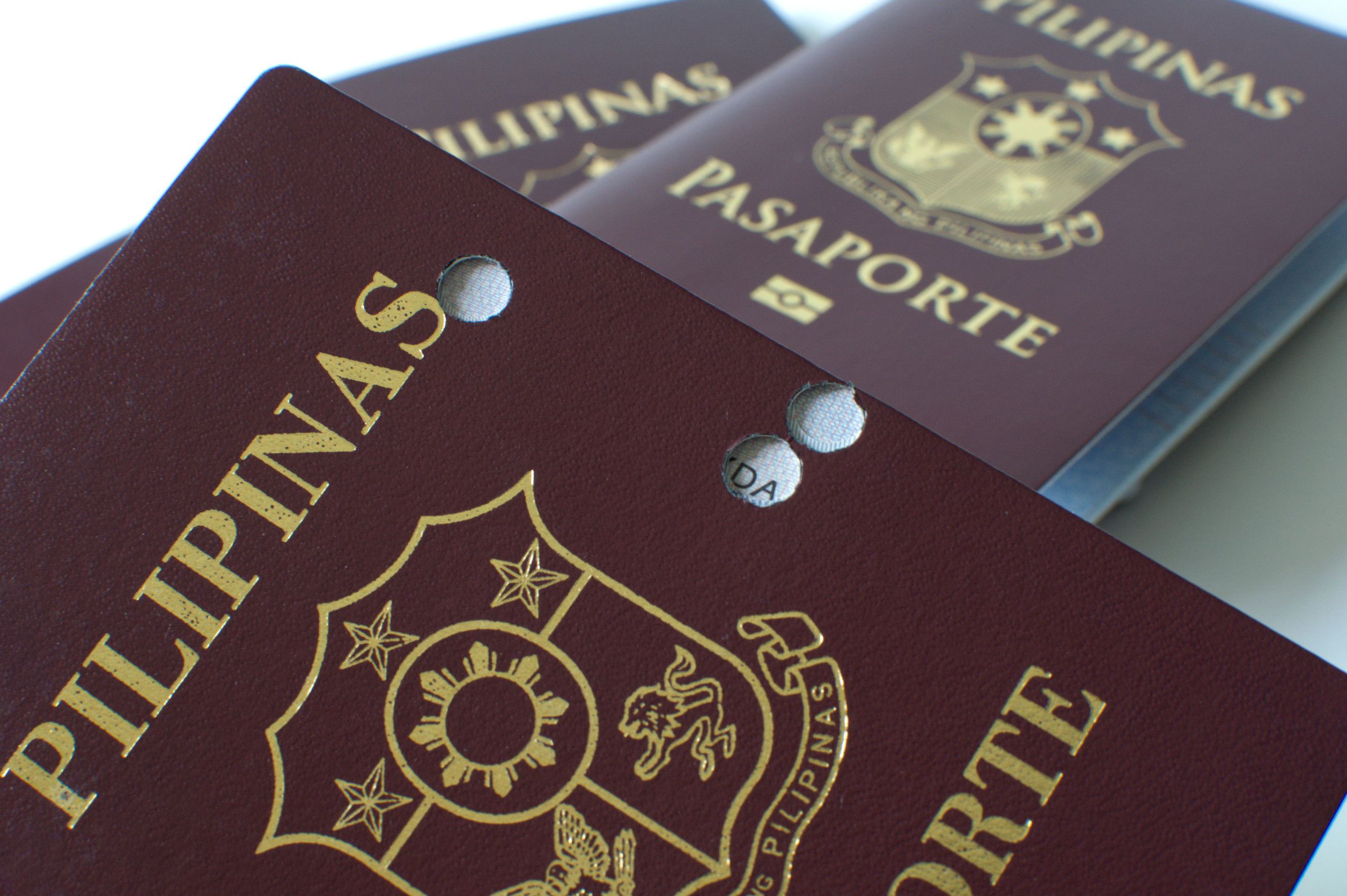 A still life of a old hole ridden Philippine passport against white background