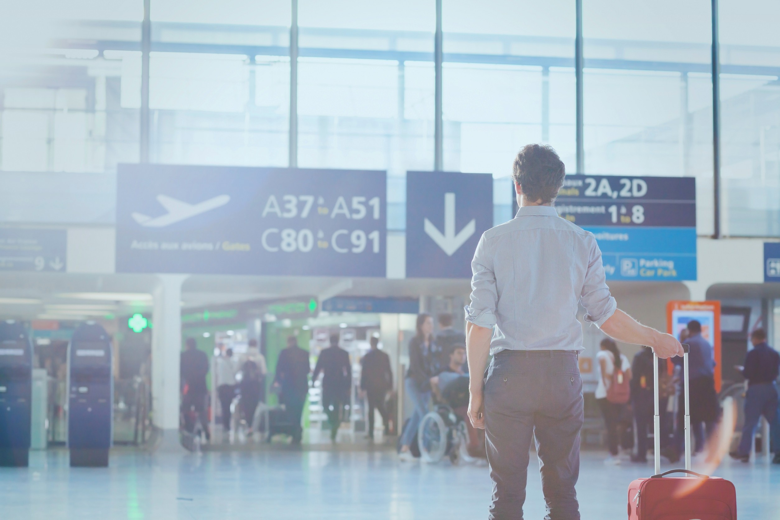 Business travel man passenger in airport waiting for the flight in modern terminal
