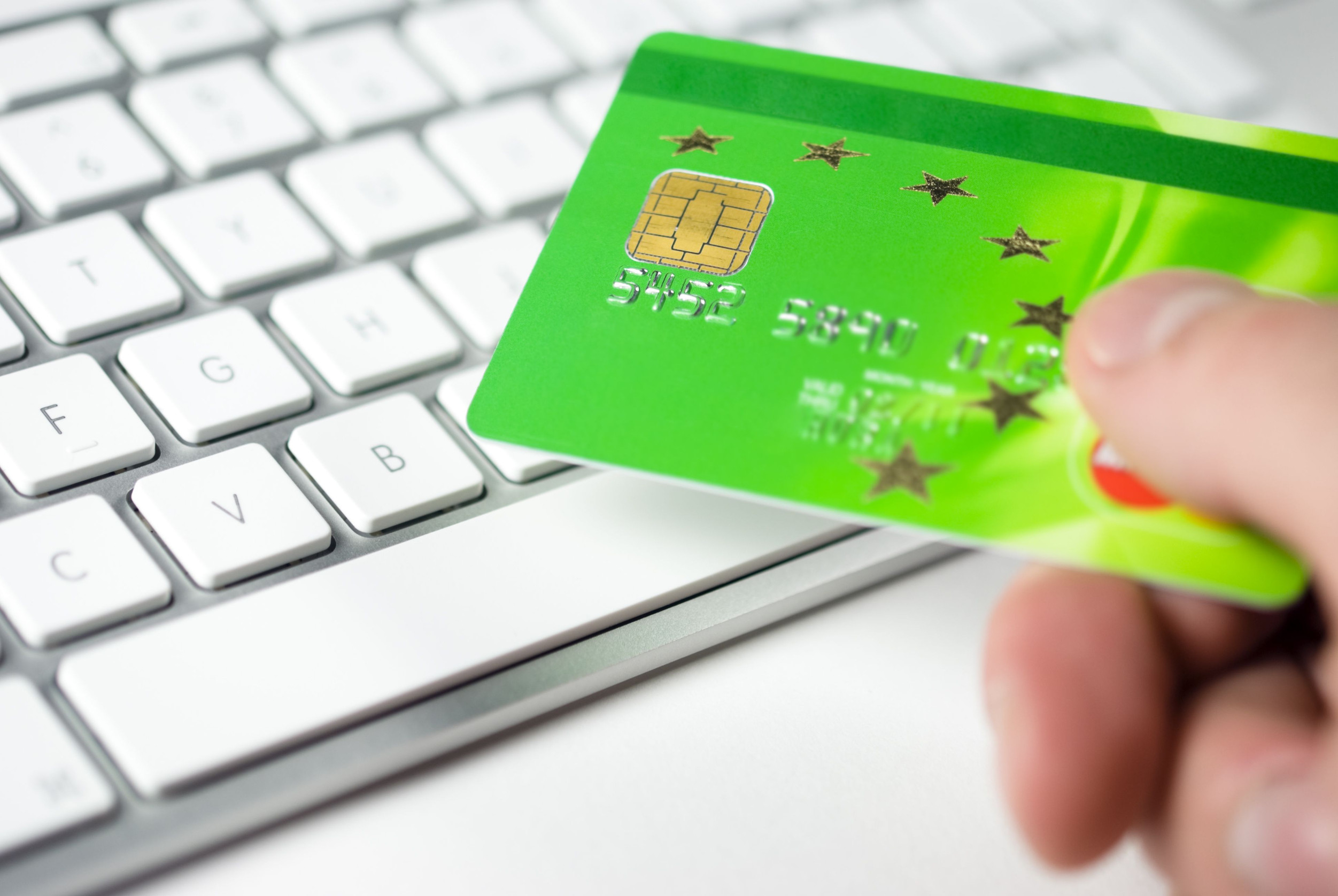 Hand holding green credit card